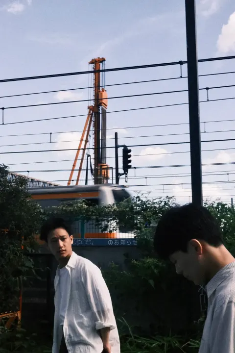 線路沿いに立つYONAGIの2人